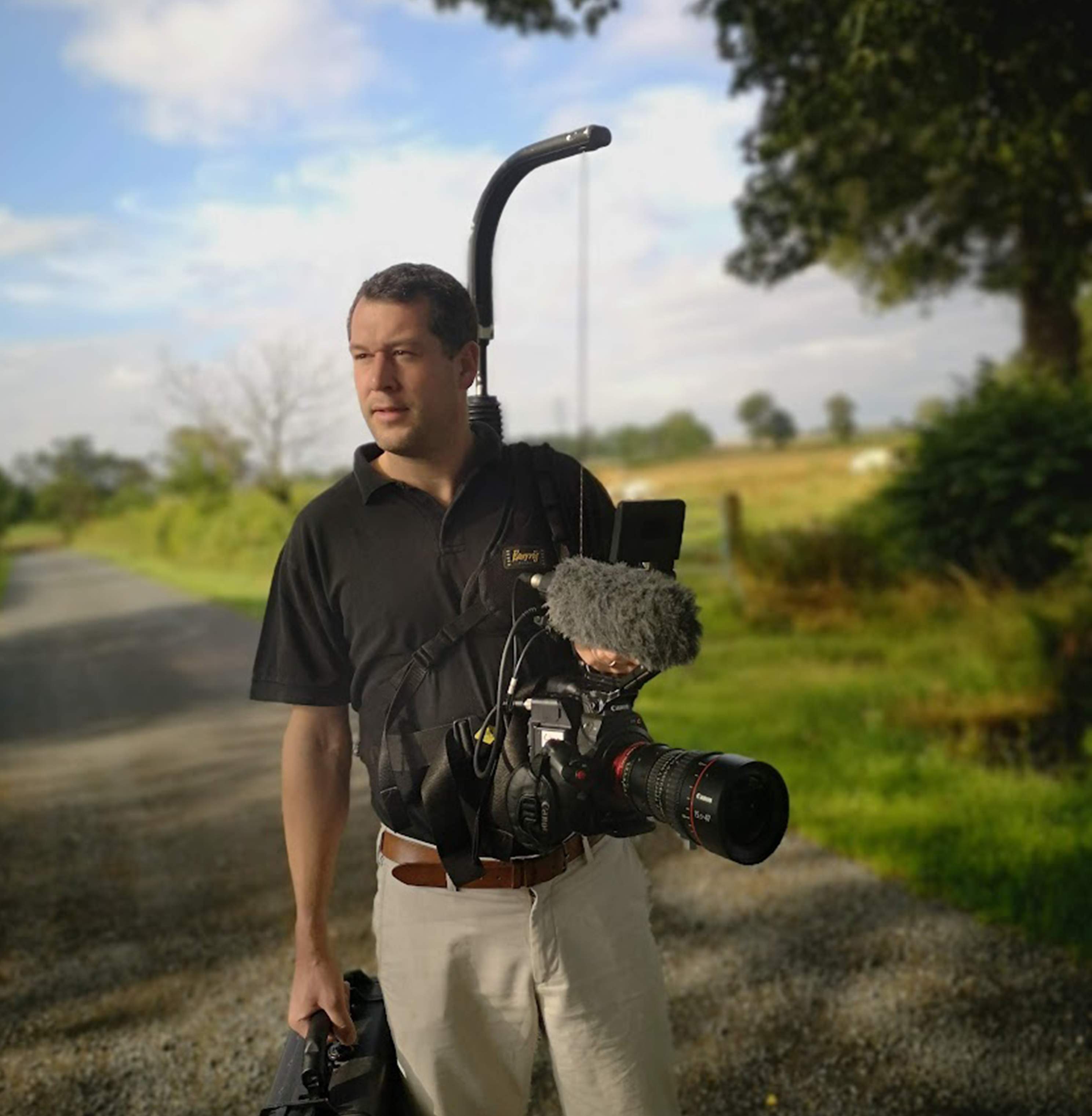 Photo d'un caméraman avec son équipement vidéo et sa caméra dans les mains
